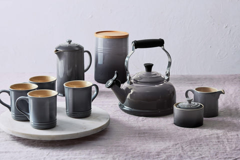 Le Creuset mug stacked beside plates to show coordinated dinnerware styling