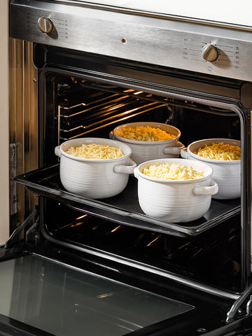 LE TAUCI bowl under broiler with melted cheese topping, demonstrates oven-to-table use
