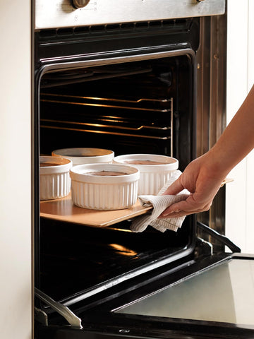 LE TAUCI ramekin in oven with crème brûlée showing even browning and oven-safe use
