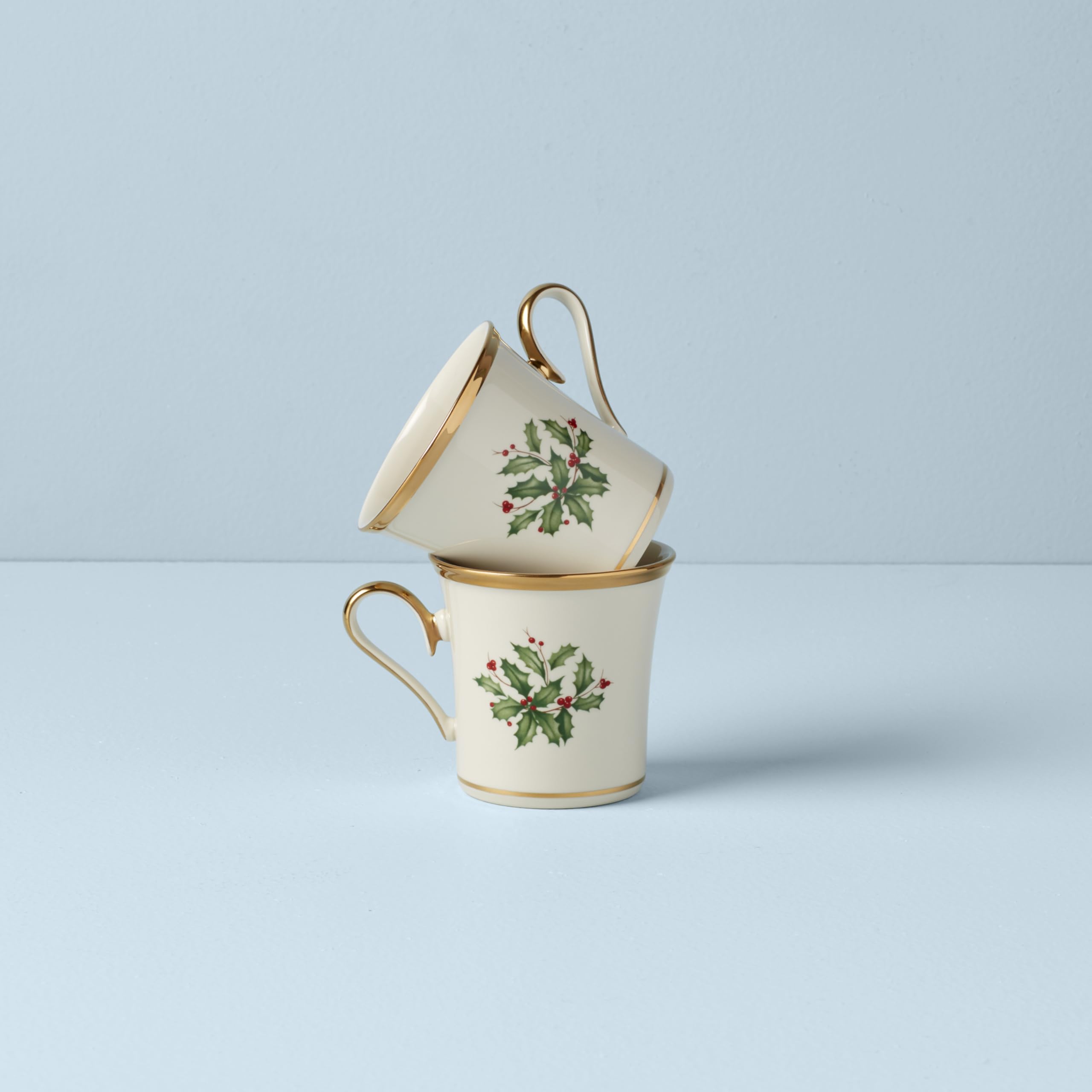 Lenox holly mug in-hand with hot cocoa showing cozy holiday use