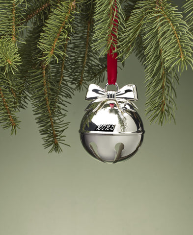 Lenox bell ornament hung on a Christmas tree adding festive sparkle and color contrast