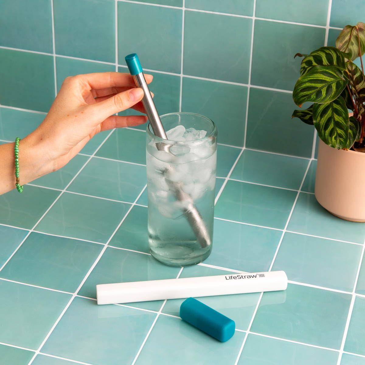 Person sipping through LifeStraw Sip from a bottle, highlighting safe-on-the-go drinking benefit