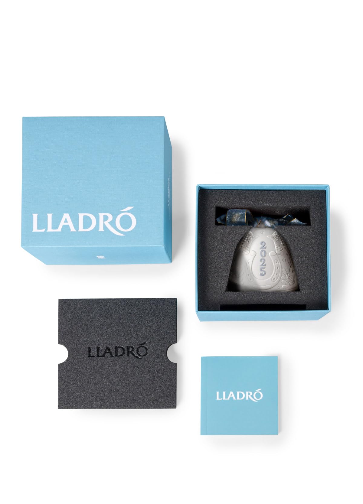 LLADRÓ bell next to packaging showing scale and secure custom presentation