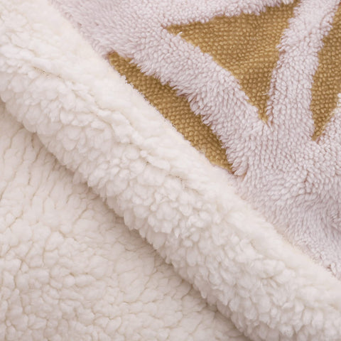 LOMAO blanket at foot of twin bed showing decorative layering and warmth