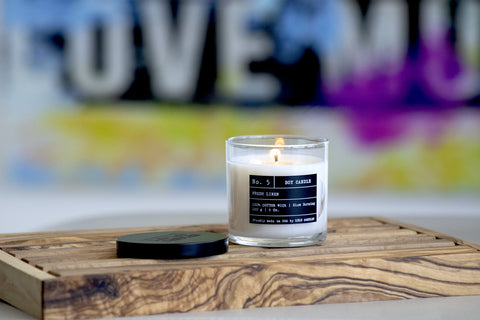 Lulu Candles next to a coffee cup to demonstrate compact 6 oz size and scale