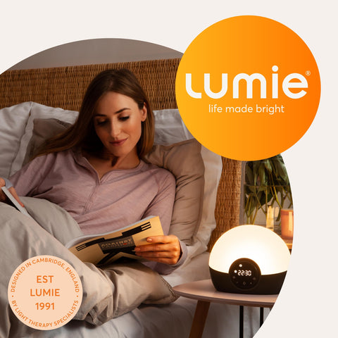 Lumie Bodyclock Glow 150 size comparison next to a book showing compact scale and bedside fit benefit