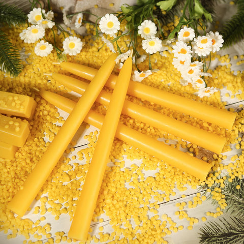 MAKALONE lit beeswax tapers on a dining table creating warm ambiance benefit