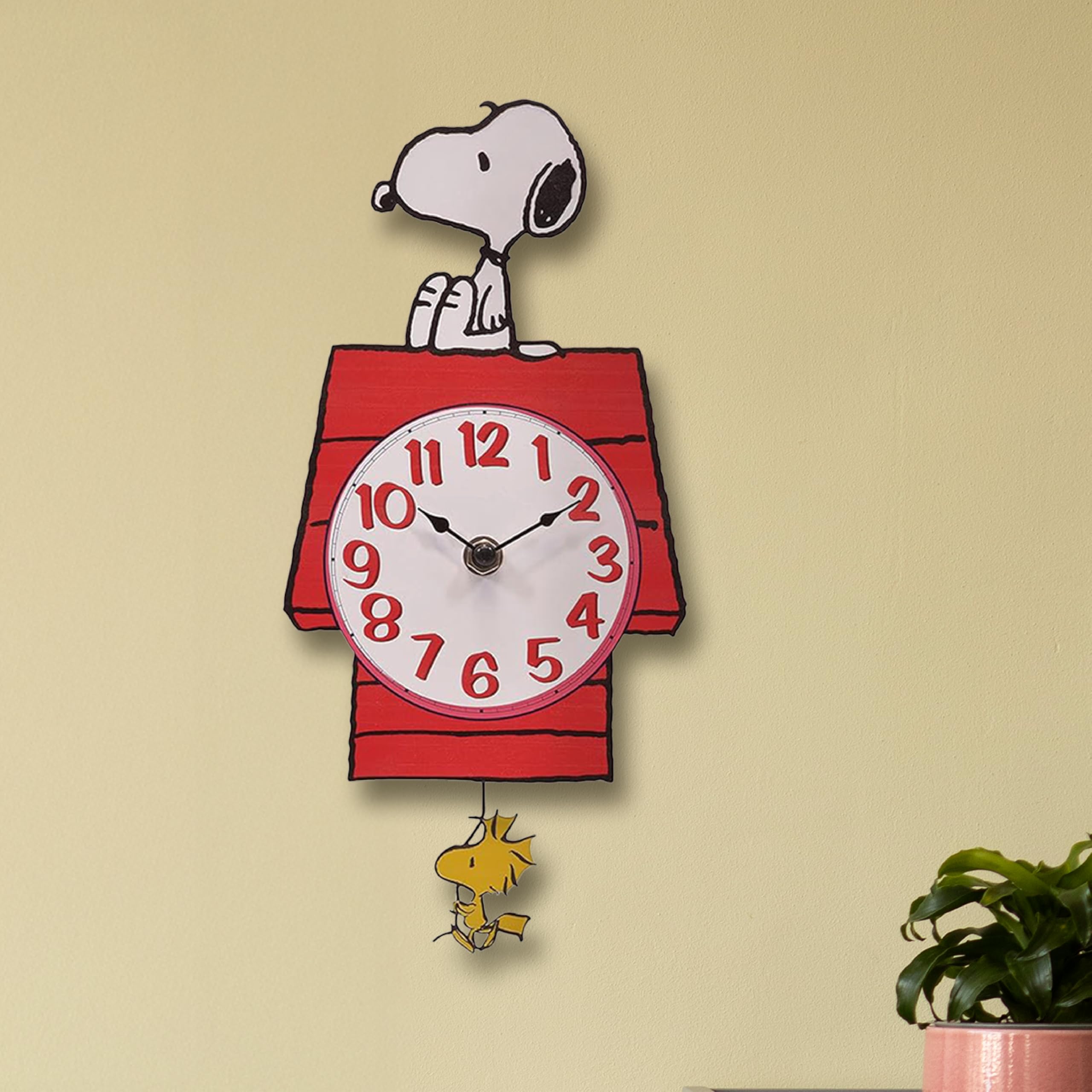 Mark Feldstein Snoopy clock next to book for size comparison benefit: shows compact 12-inch scale