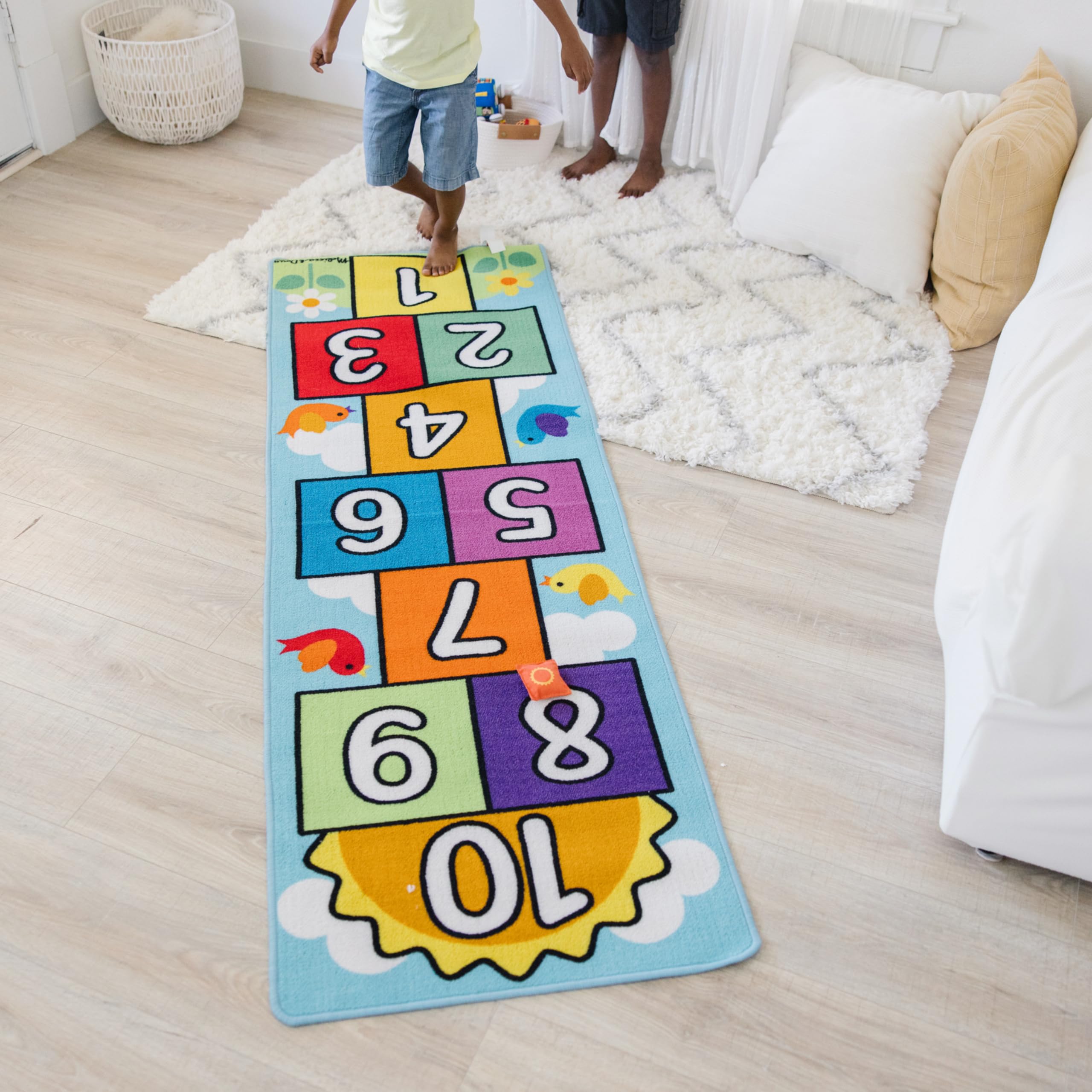 Melissa & Doug rug with child stepping on squares to show scale and encourage gross motor skills