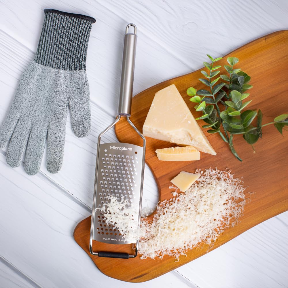 Microplane grating cheese in use showing fast coarse shreds and efficiency