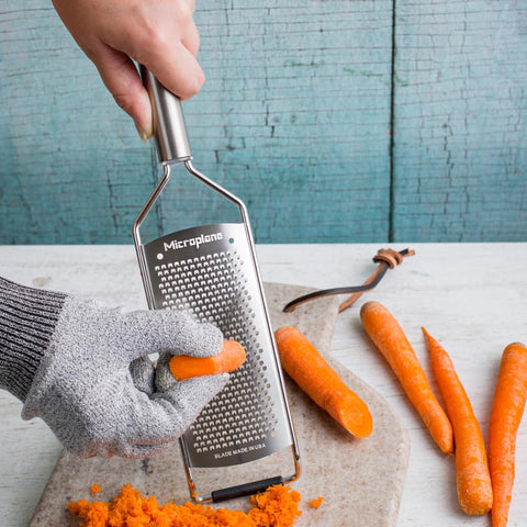 Microplane grater in use shaving Parmesan into a bowl for quick prep