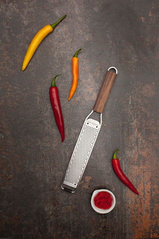 Microplane scale comparison next to kitchen knife shows compact size