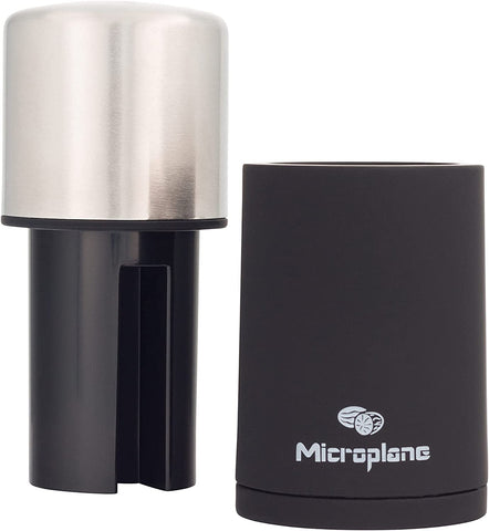 Microplane grating cinnamon stick into bowl for immediate aroma boost in recipes
