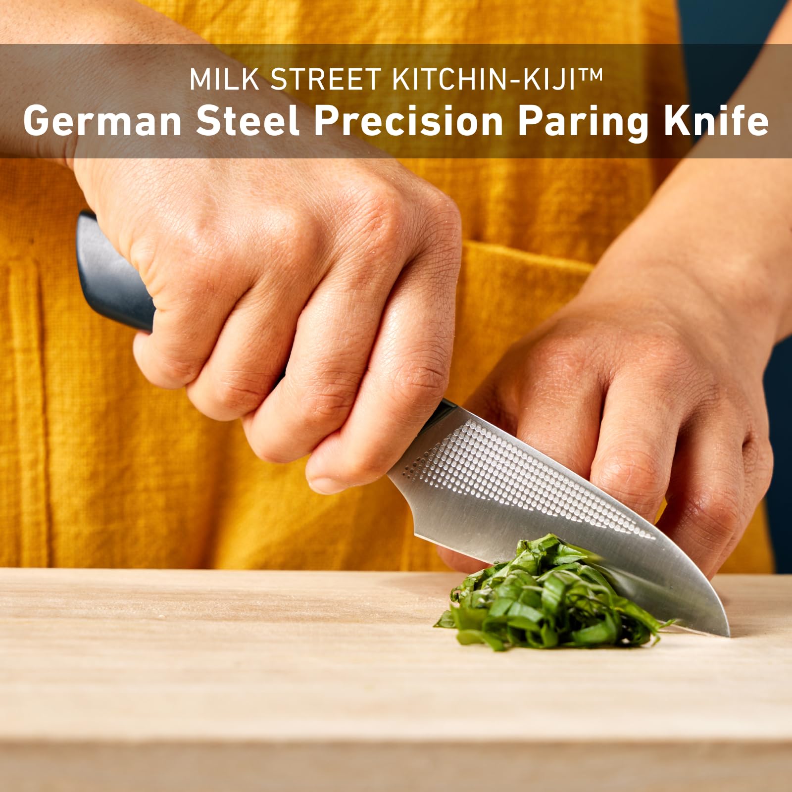 Milk Street Kitchin-kiji next to a chef knife to show compact size advantage