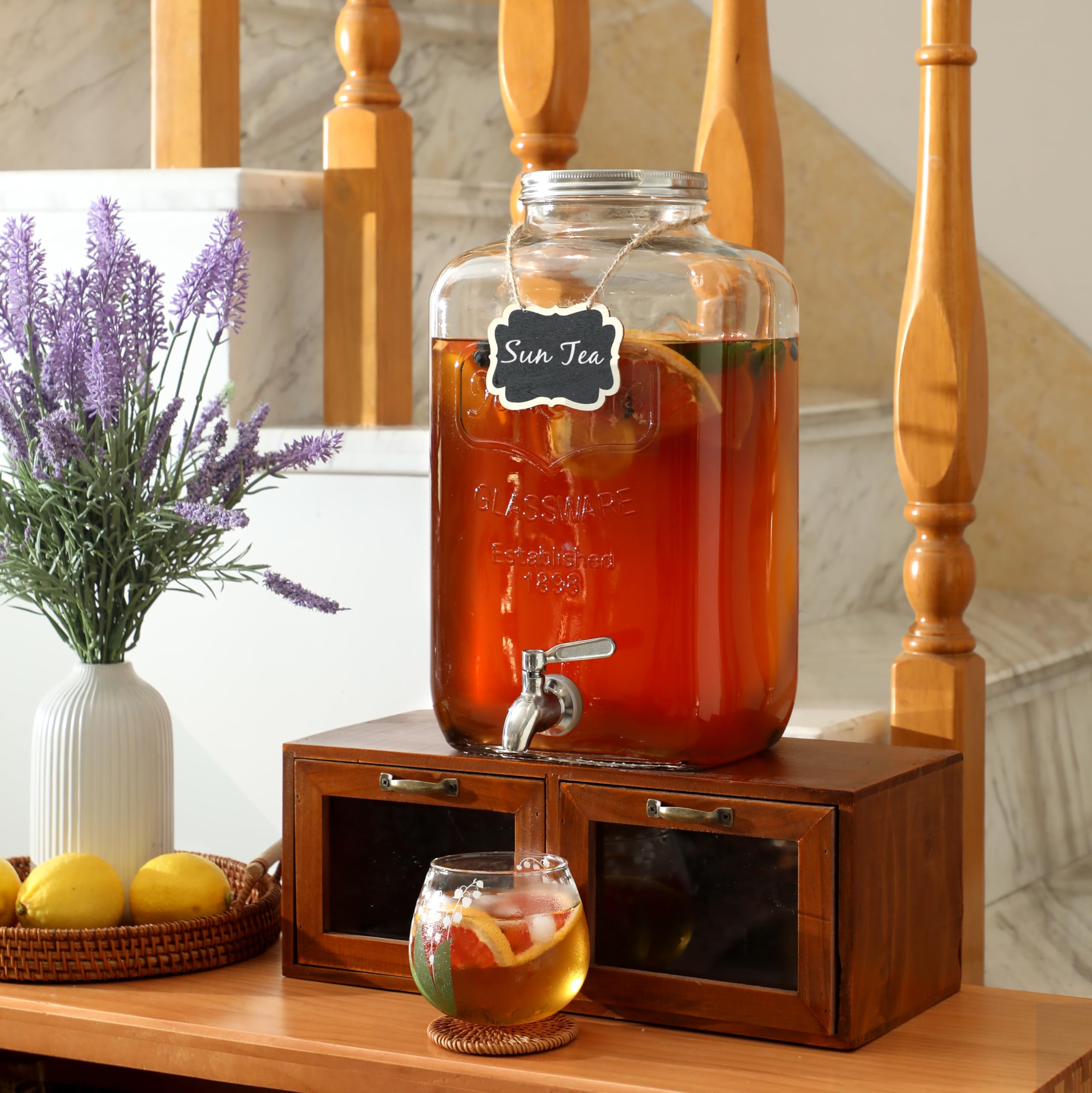 MiraEase dispenser next to cups showing 2-gallon capacity and scale benefit