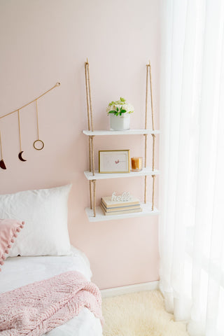 Mkono shelf in use on living room wall displaying plants and photos for visual warmth