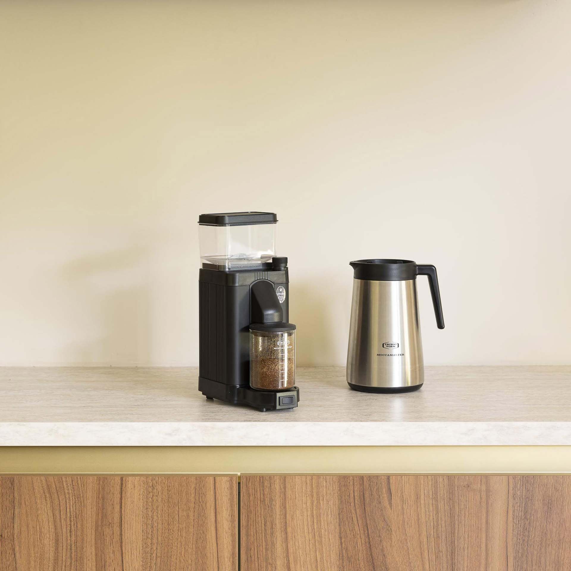 Moccamaster carafe beside cups showing 40 oz capacity for multiple servings