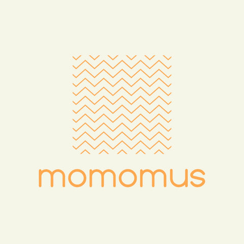 MOMOMUS blanket on grass at campsite showing multipurpose utility