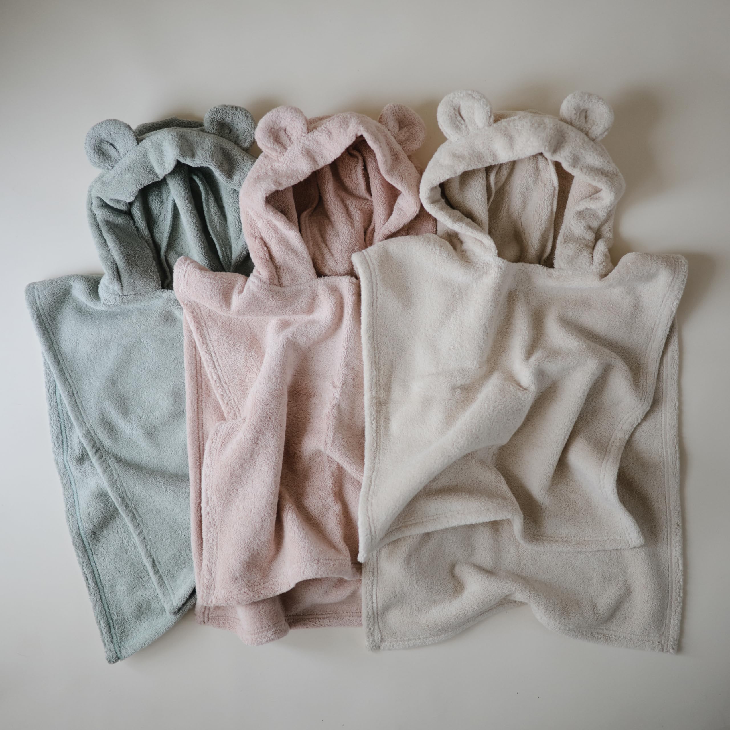 mushie neatly folded poncho showing neat storage and gifting appeal