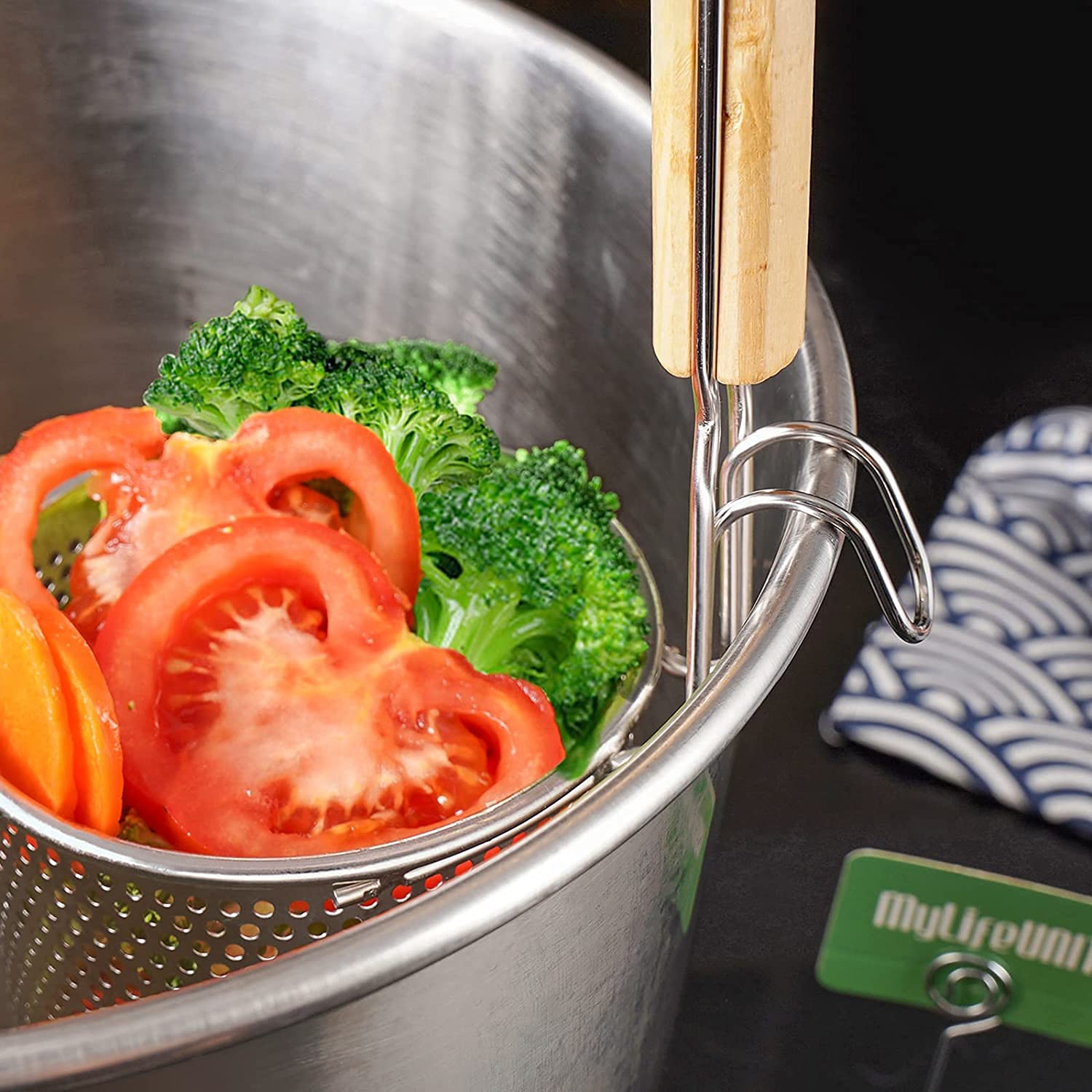 MyLifeUNIT strainer hanging in a pot while lifting pasta, reducing splashes and easing draining