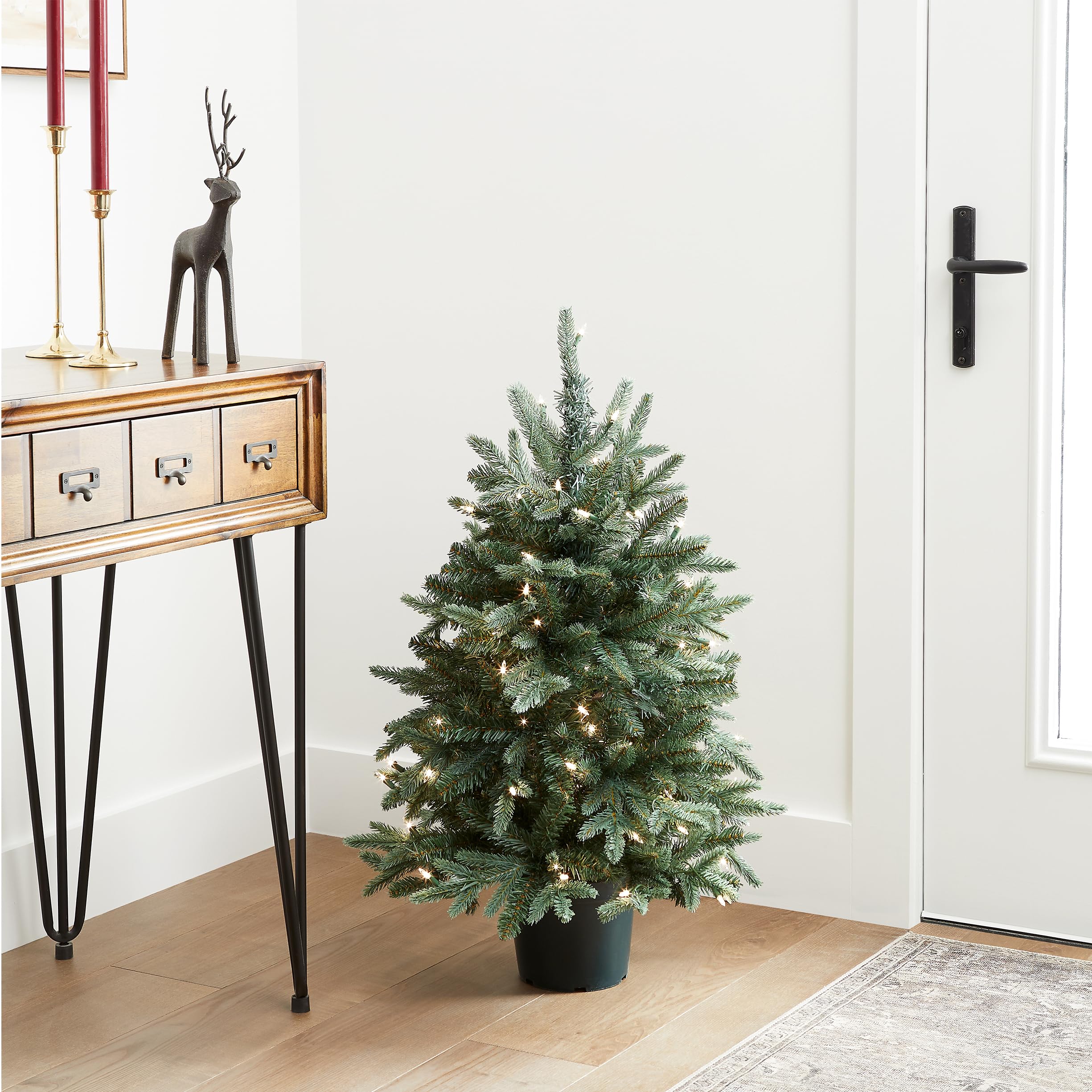 National Tree Company mini tree styled in a doorway demonstrating compact fit and festive enhancement