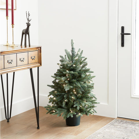 National Tree Company mini tree styled in a doorway demonstrating compact fit and festive enhancement