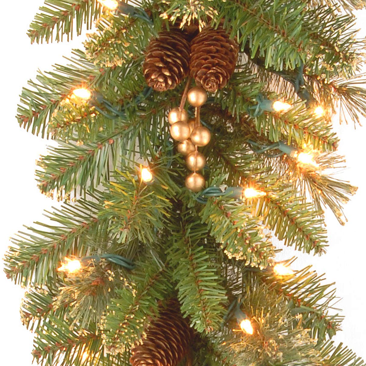 National Tree Company garland draped on mantel lit up to create inviting holiday atmosphere