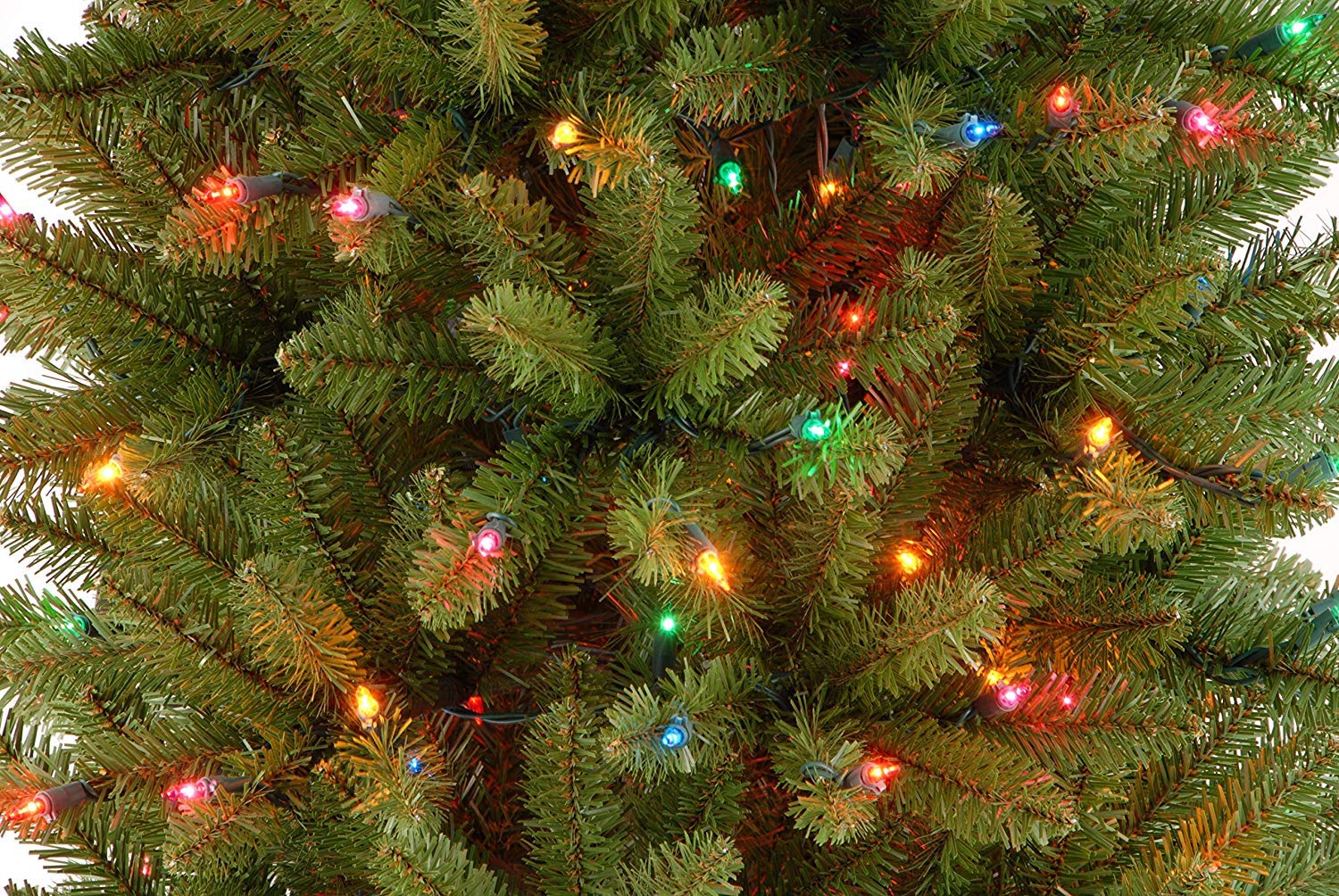National Tree Company Kingswood Fir beside a sofa demonstrating 7.5ft height and space-saving profile