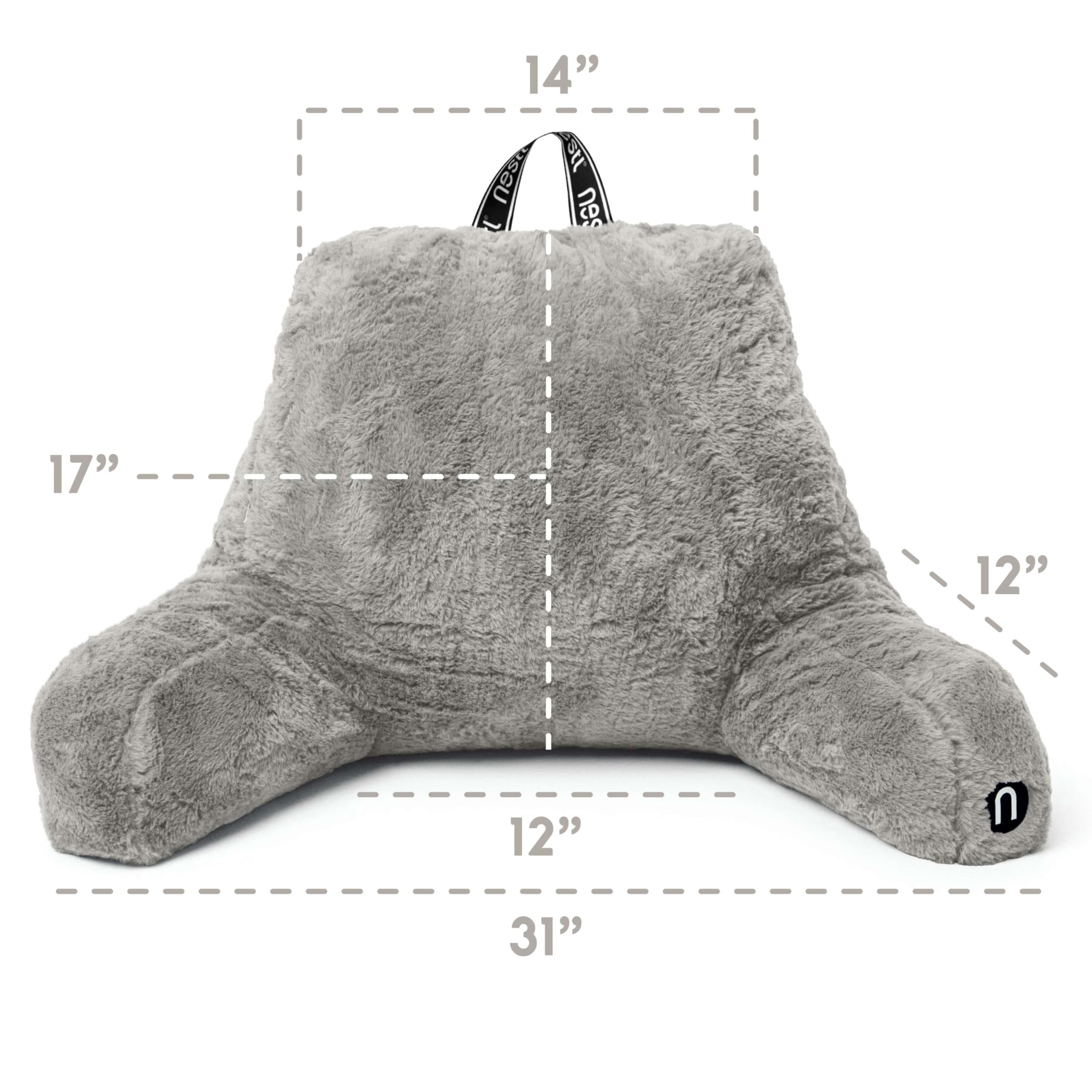 Nestl pillow styled on bed with person reading showing improved upright comfort