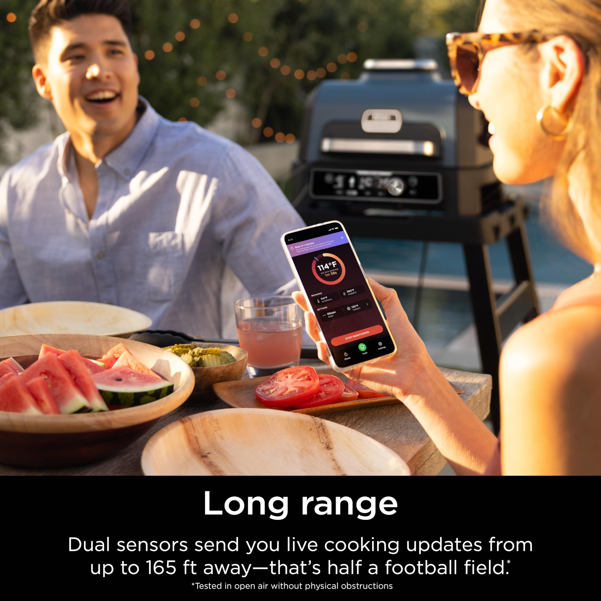 Backyard grilling scene with Ninja ProChef charging case on table illustrating hands-free multitasking