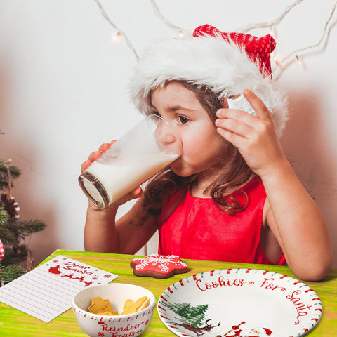 Nitial full set styled on a mantel with tree background creating a warm holiday atmosphere