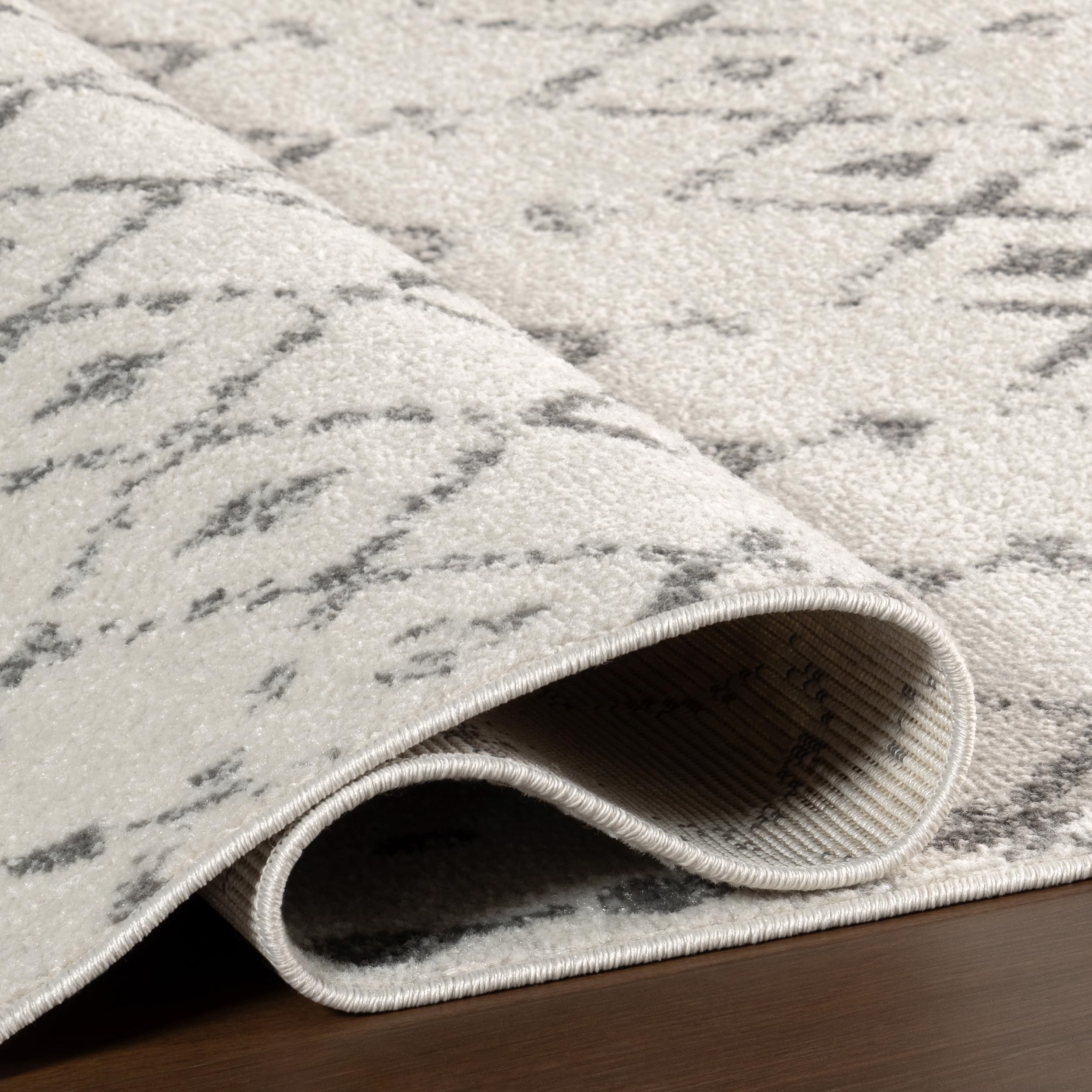 nuLOOM Blythe styled under sofa demonstrating anchor effect and coordinated decor