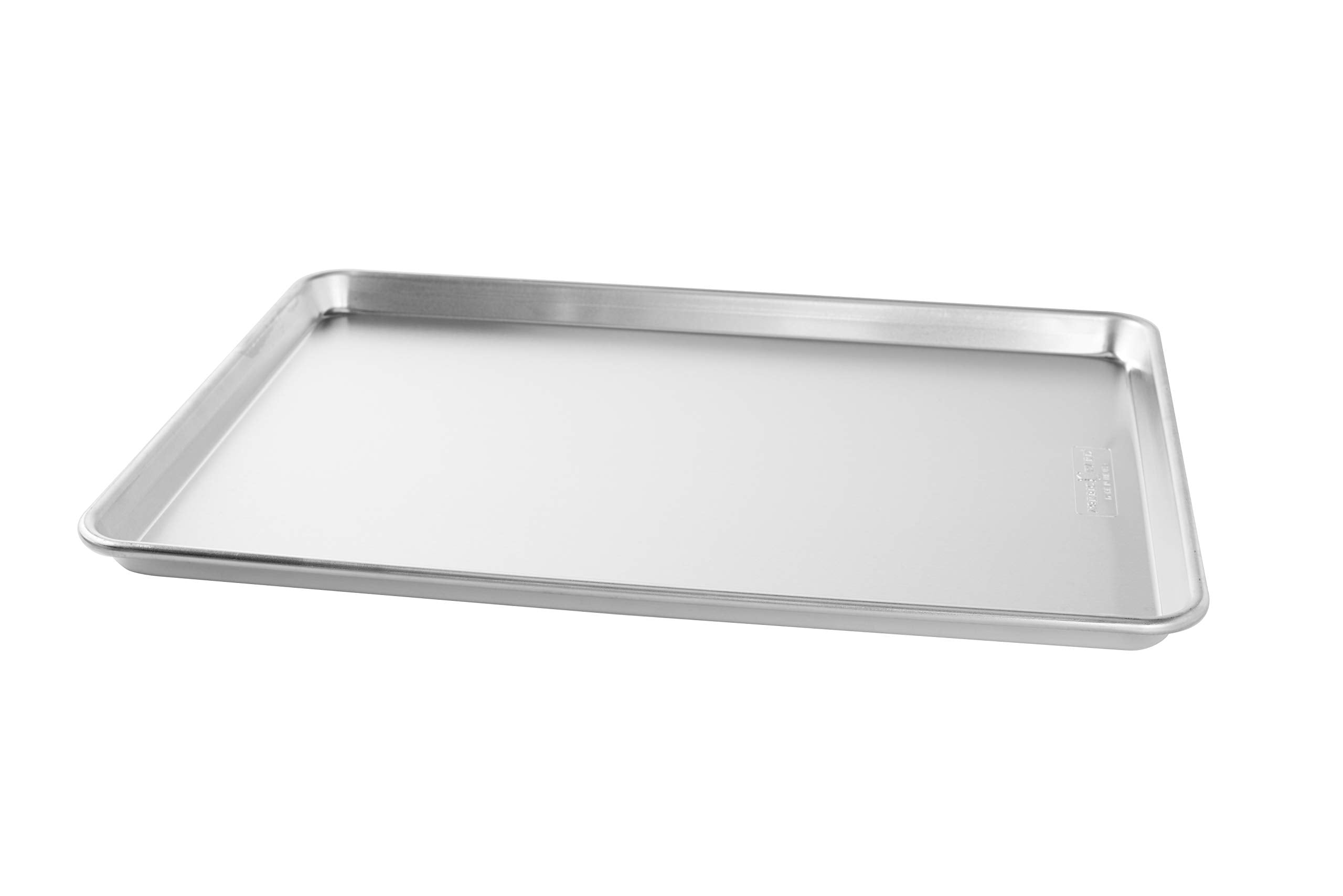 Nordic Ware pan beside standard sheet to show larger size and expanded baking capacity benefit