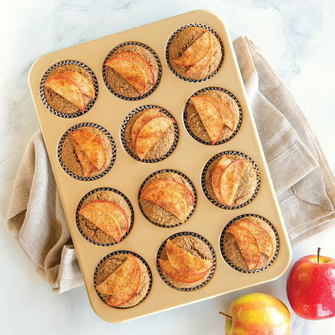 Nordic Ware pan filled with baked muffins demonstrating uniform rise and browning across cups