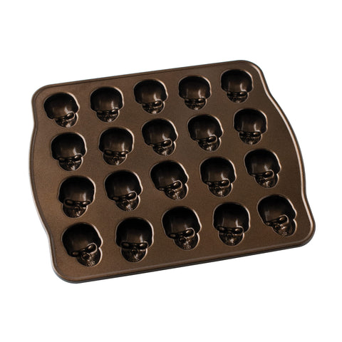 Nordic Ware pan in use as batter is poured into skull cavities for consistent fills