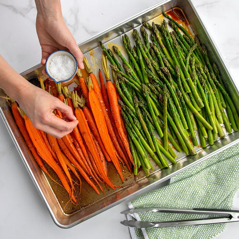 Nordic Ware pan in oven roasting vegetables for consistent browning benefit