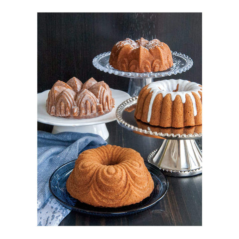 Nordic Ware pan beside sliced cake and measuring cup showing size and serving scale
