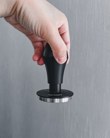 Normcore tamping in a portafilter demonstrating leveled puck benefit