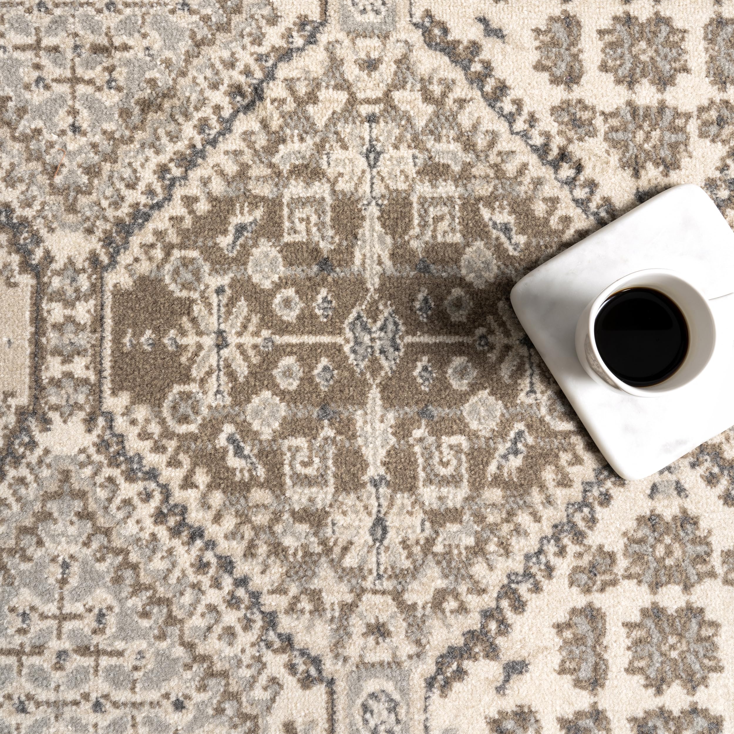 nuLOOM Becca beside sofa showing scale against furniture and space-definition benefit