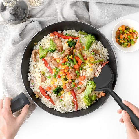 oannao turner sliding under food in a nonstick pan to protect coating