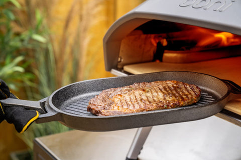 ooni Grizzler searing steak on the griddle showcasing strong sear and flavor development