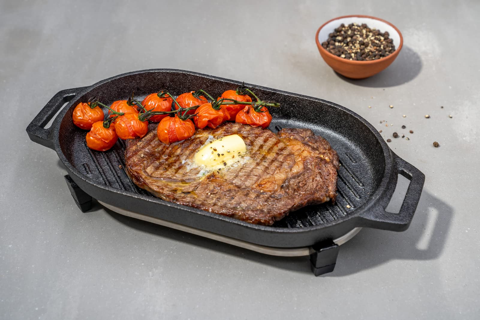 ooni Grizzler stainless steel trivet closeup protecting surfaces and stabilizing pan