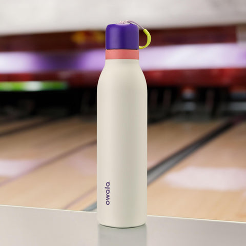 Owala FreeSip Twist next to hand and keys to show 18 oz size and portability