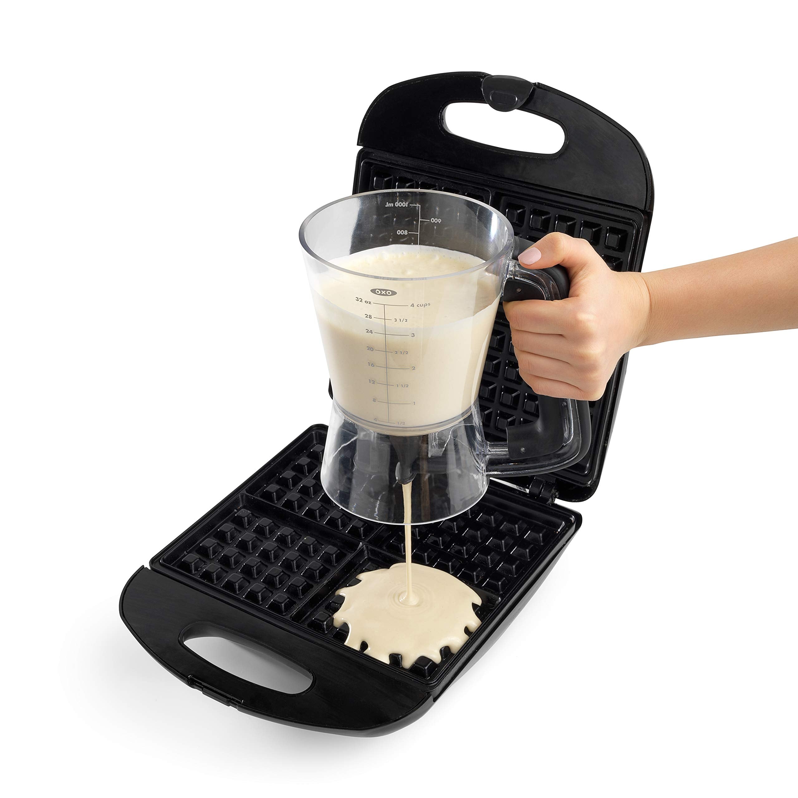 OXO dispenser pouring pancake batter precisely into a hot griddle for uniform size