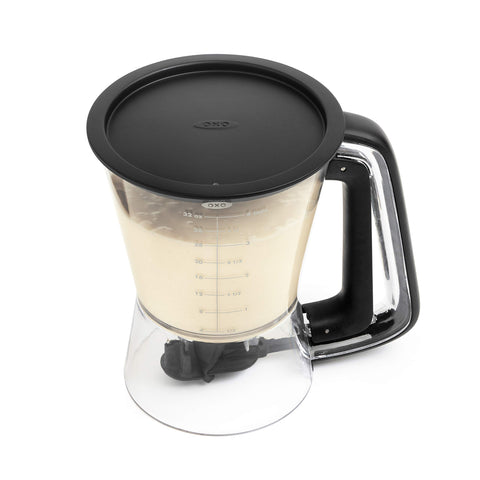 OXO dispenser next to measuring cup for size and scale comparison in kitchen