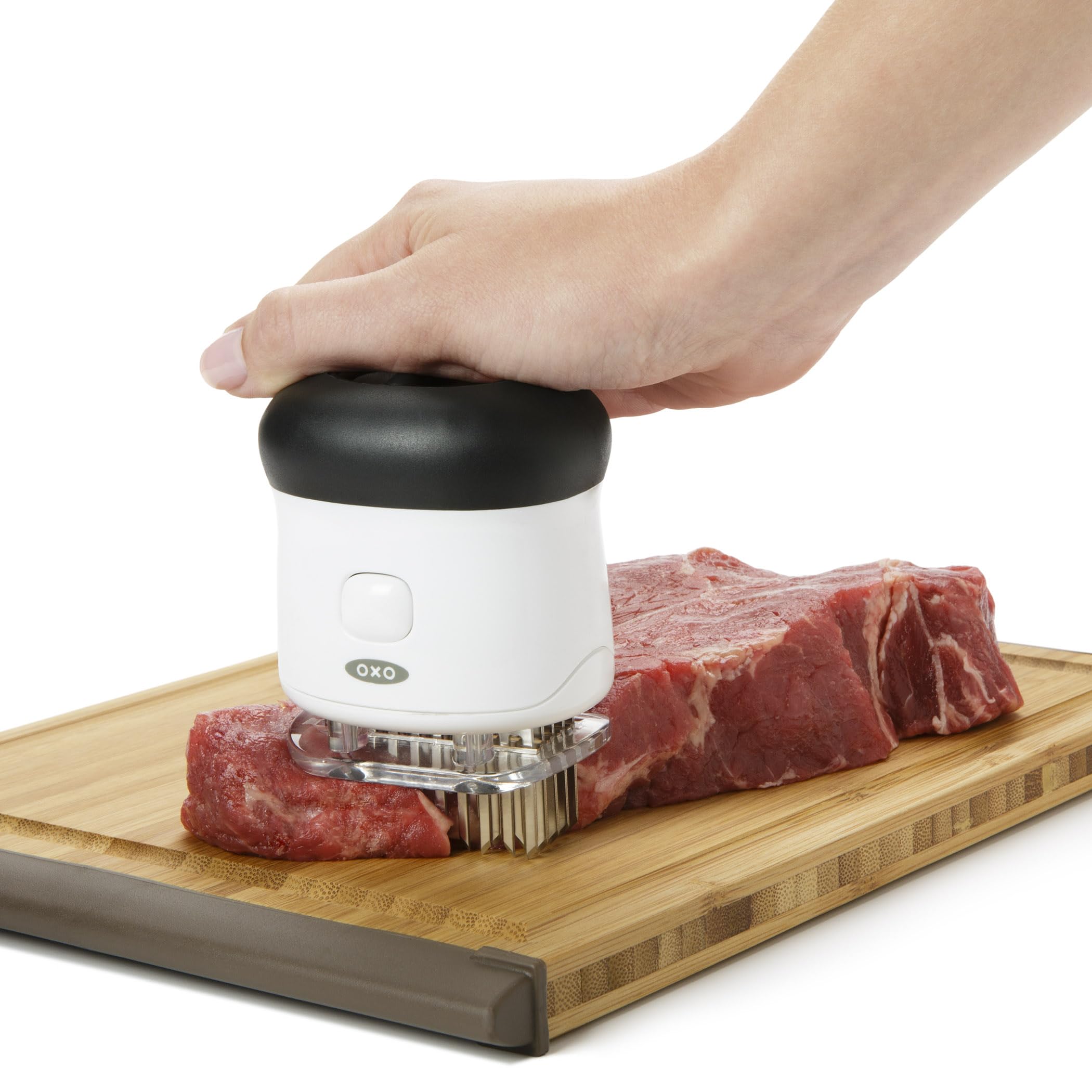 OXO tenderizer in use on steak illustrating quicker flavor absorption benefit