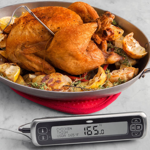 OXO thermometer next to grill demonstrating outdoor cooking control