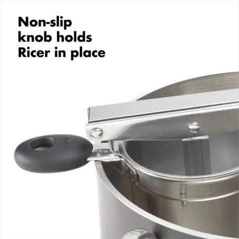 OXO ricer in use over bowl producing uniform strands for butter-ready mash