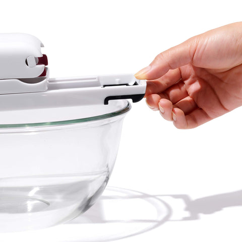OXO user pressing cherries one-handed to demonstrate effortless operation