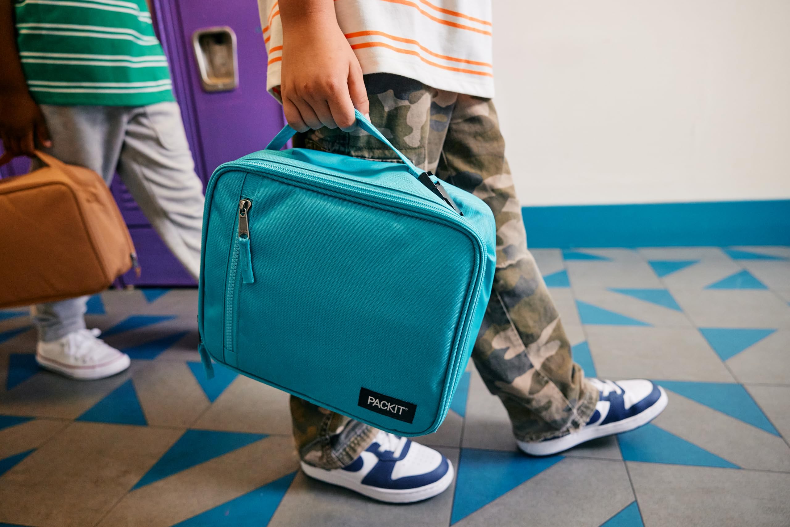 PackIt Freezable Classic next to water bottle for scale demonstrating room for bottle and lunch essentials